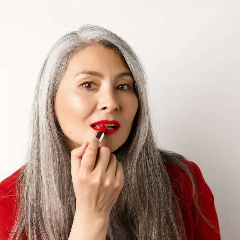 Woman applying red lipstick.